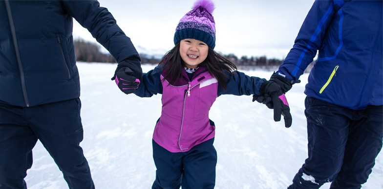 Girl Ice Skating with Parents Helping